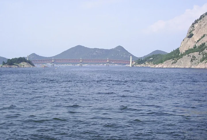 A suspension bridge spans blue water between rocky green islands beside Seonyudo in the Gogunsan Islands near Gunsan.