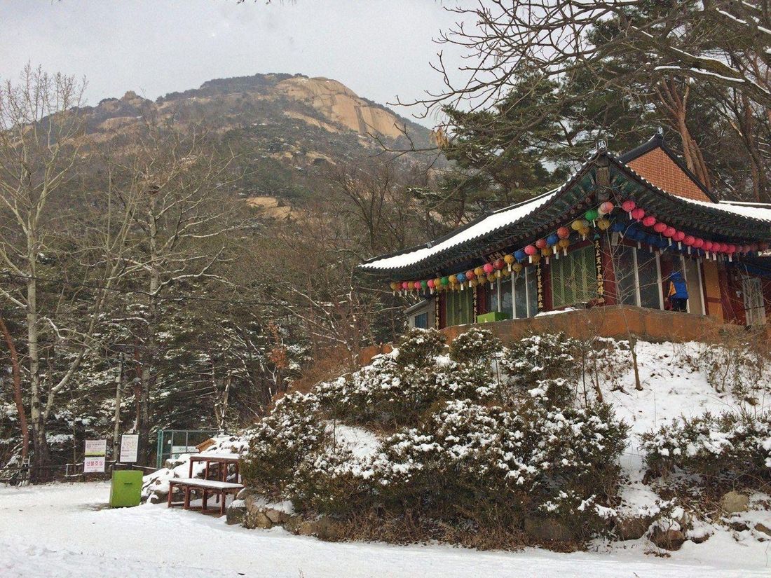 Colourful lanterns on a temple beneath snowy Bukhansan slopes